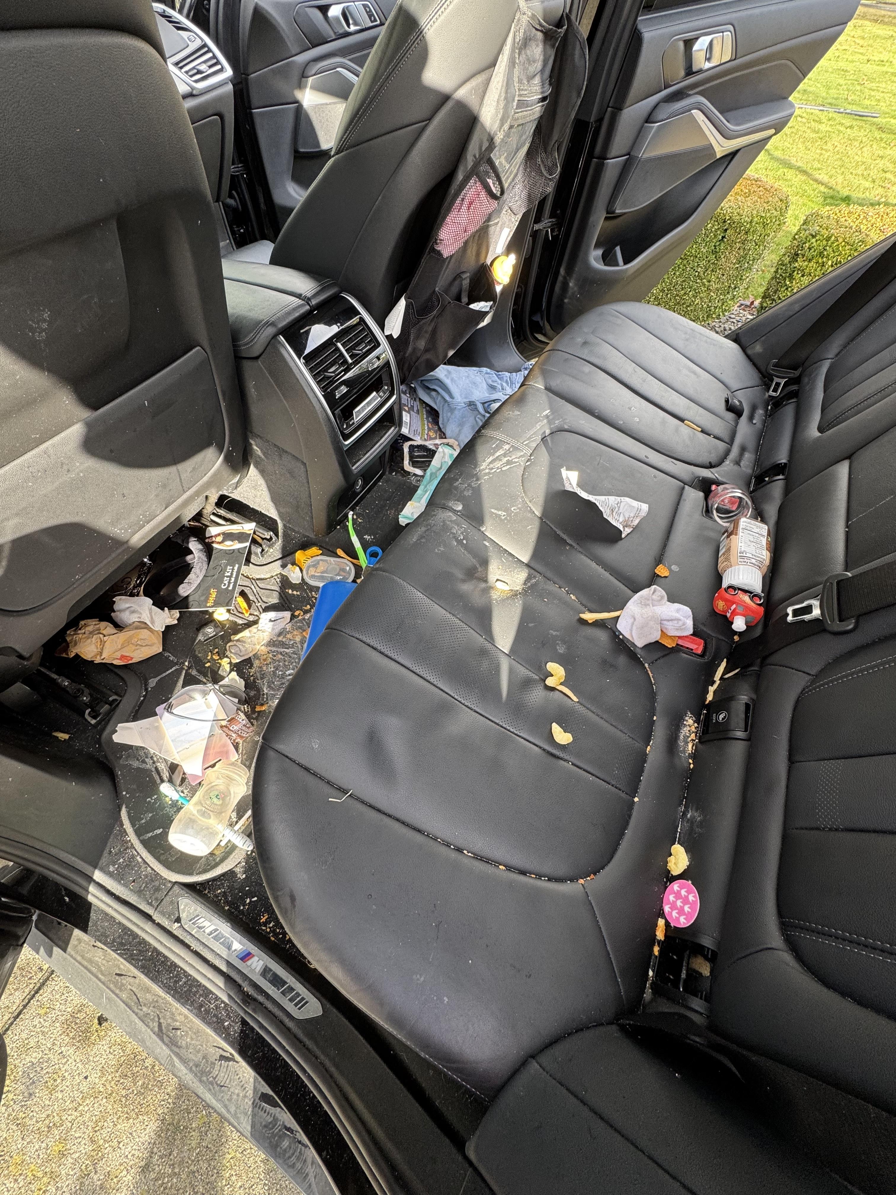 Before professional car interior detailing in Bellingham - dirty back seat with stains and debris from Victory Lap Mobile Detailing